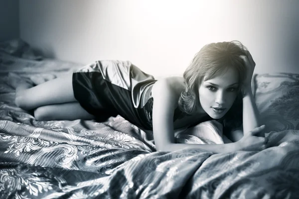 Young beautiful woman lying on a bed