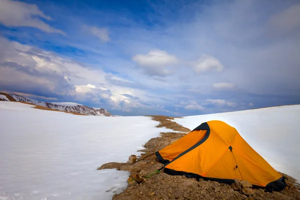 Orange tent in snow mountains