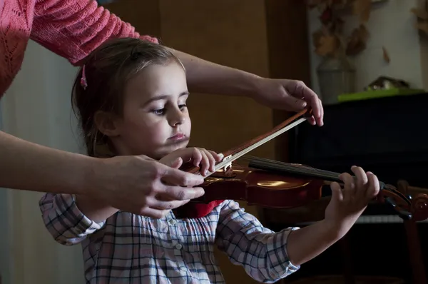 Adorable little girl learning violin playing