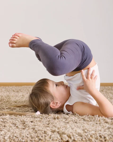 Cute little girl yoga exercising