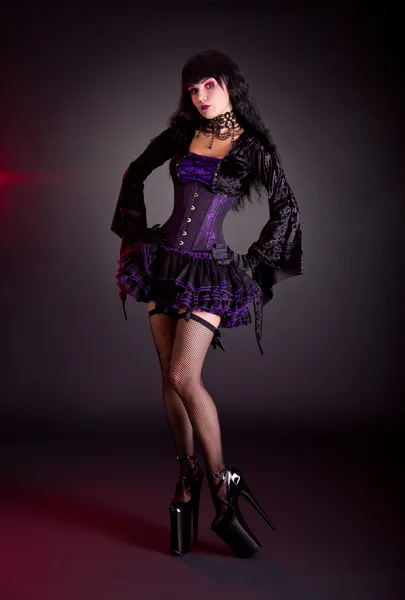 Sexy young woman in Victorian purple and black Halloween outfit