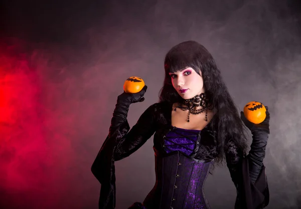 Portrait of attractive witch in purple gothic Halloween costume