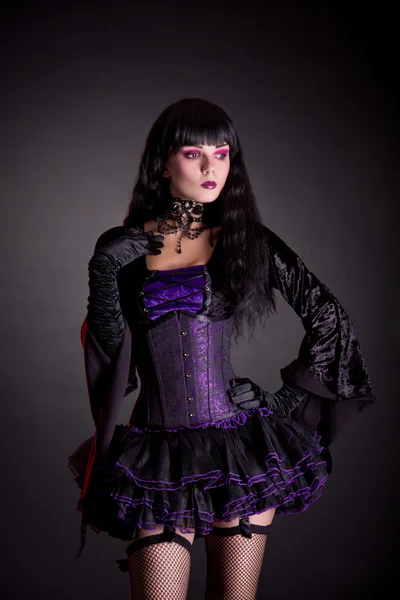 Romantic witch in purple and black gothic Halloween outfit