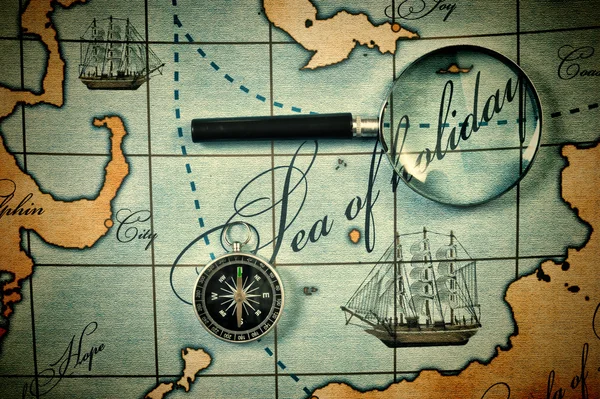 Old magnifier and compass on a stylized map