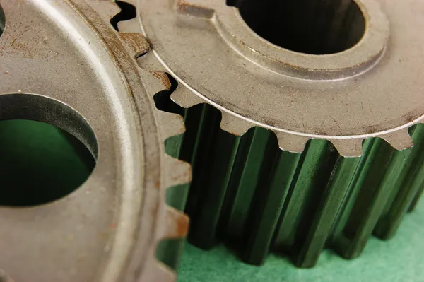 Two gears on a green background