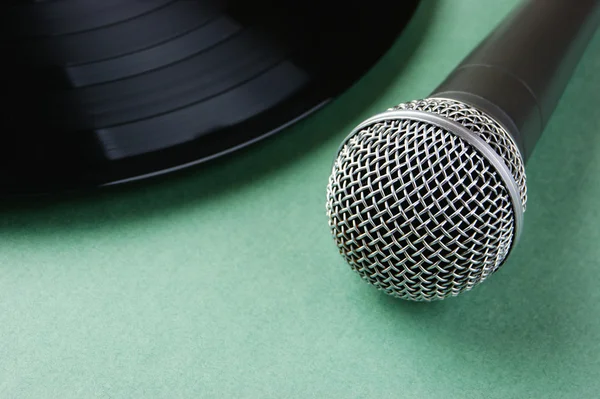 Microphone and old vinyl record on a green background