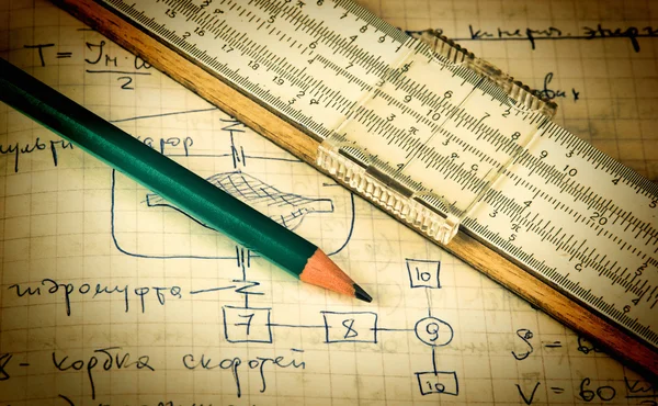 Pencil and a slide rule on the old page with the calculations in