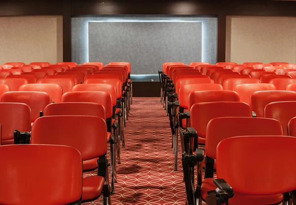 Rows of red chairs in empty conference hall