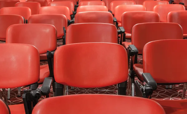 Rows of red chairs in empty conference hall
