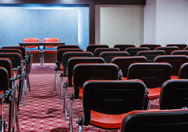 Rows of red chairs in empty conference hall