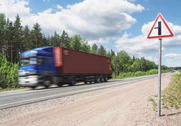 Blue truck speeding on country highway, motional blur
