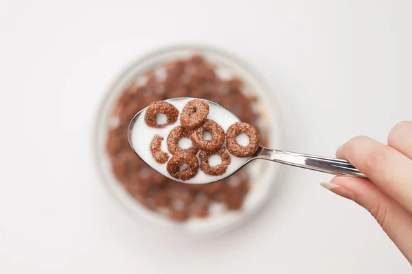 Spoon full of chocolate ringlets in hand close-up breakfast conc