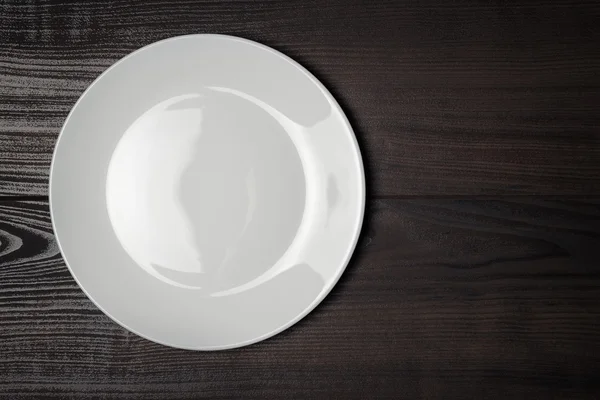 White plate on the wooden brown table