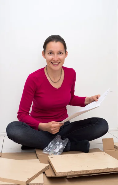 Woman looking at instructions on how to assemble furniture