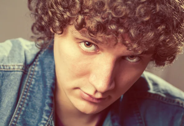 Detailed portrait of a young caucasian guy with curly hair