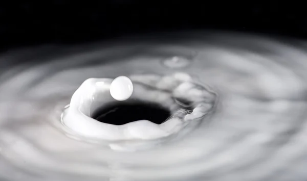 Round droplets of milk over the circles on the liquid