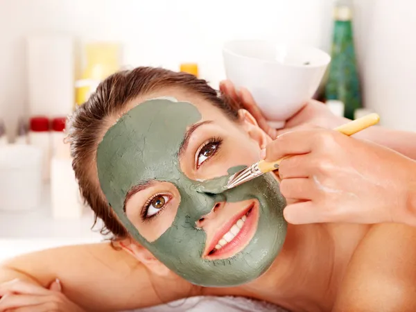 Clay facial mask in beauty spa.