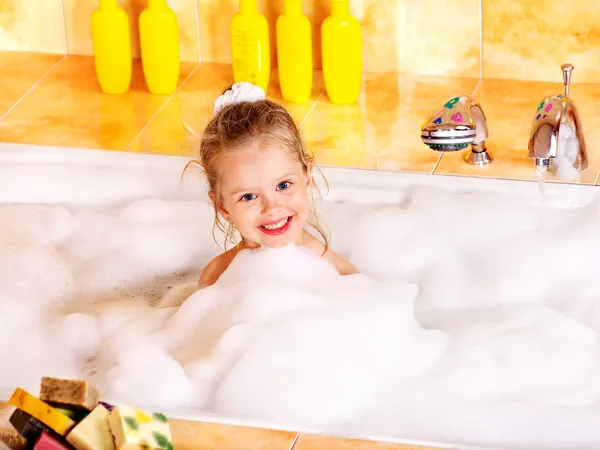 Child washing in bubble bath .