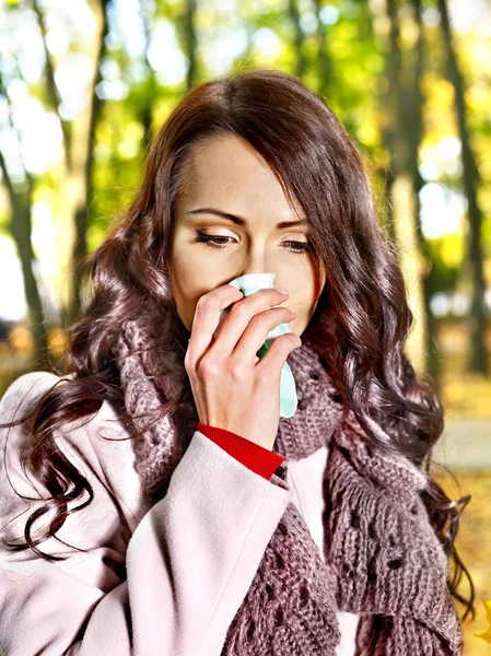 Woman sneezing handkerchief outdoor.