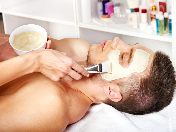 Clay facial mask in beauty spa.