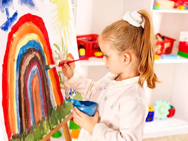 Child drawing on the easel.