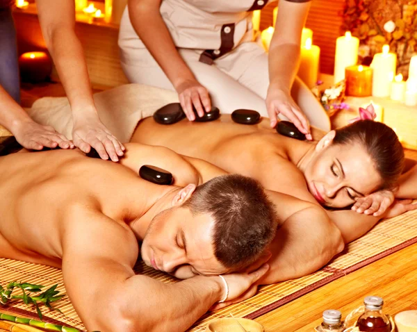 Woman and man getting stone therapy massage in spa.