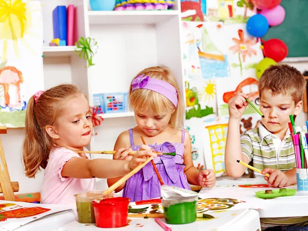 Child painting at easel.