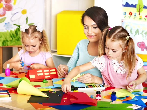 Children with teacher at classroom.