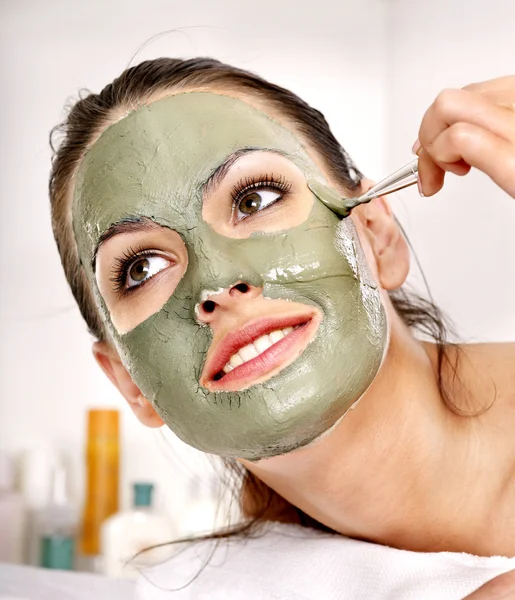 Clay facial mask in beauty spa.