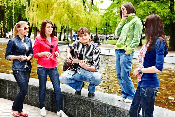 Group of people in city park listen music.