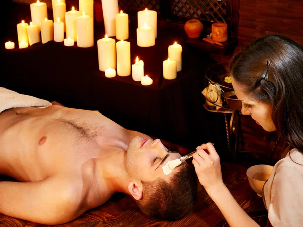 Clay facial mask in beauty spa.