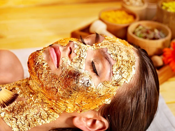 Woman getting facial mask .
