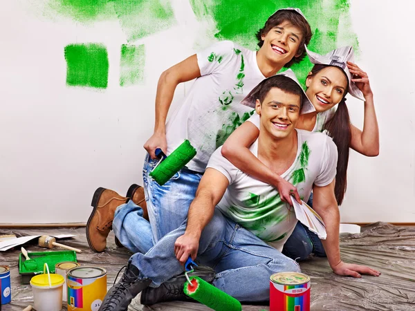 Group people paint wall at home.