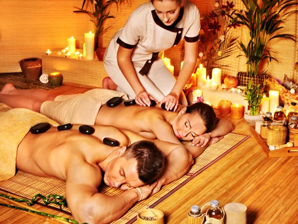 Woman and man getting stone therapy massage