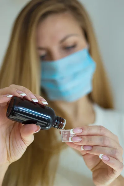 Woman in mask hand holding medicine