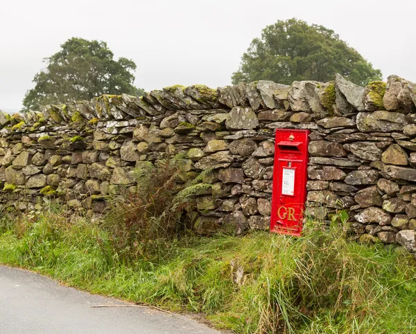 Old King George red post box in stone wall