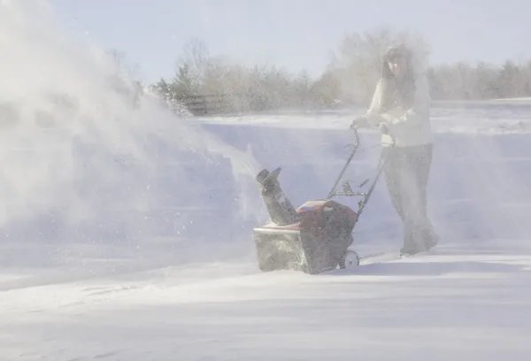 Young woman clearing drive with snowblower