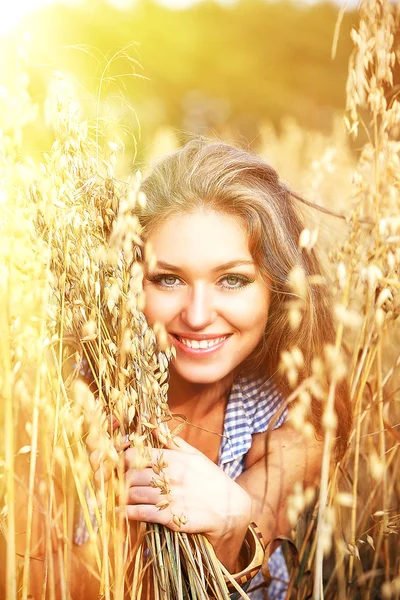 Young smiling woman in white dress standing in field