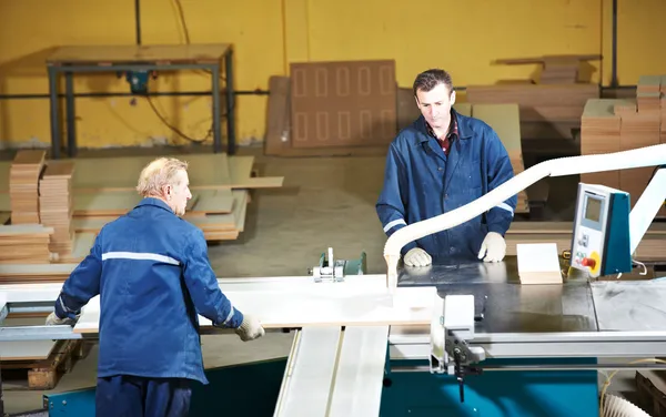 Workers at wood processing with circ saw