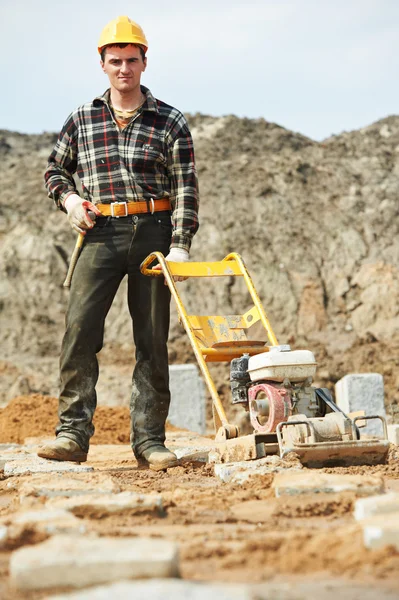 Concrete worker work with compactor