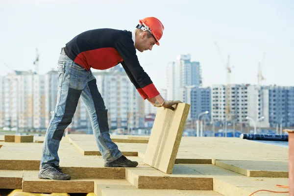 Roofer worker installing roof insulation material