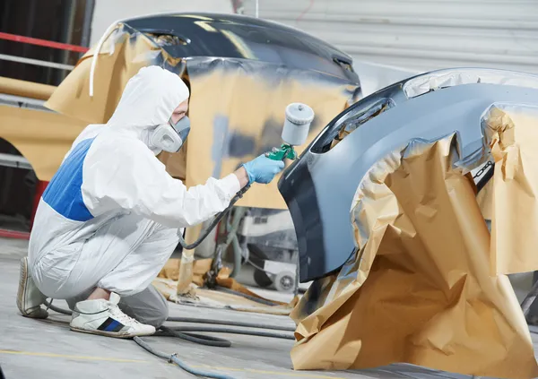 Auto mechanic painting car bumper