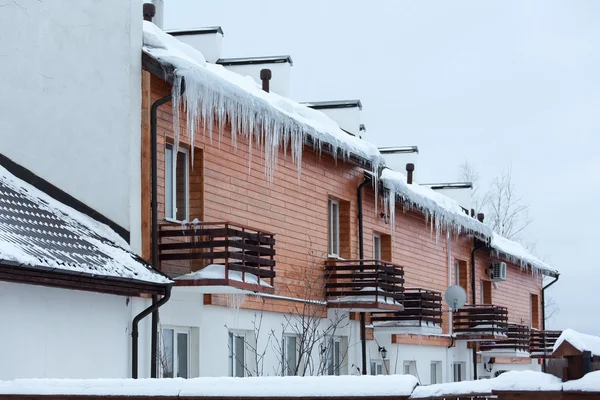 Overhanging icicles on the house roof over balconies