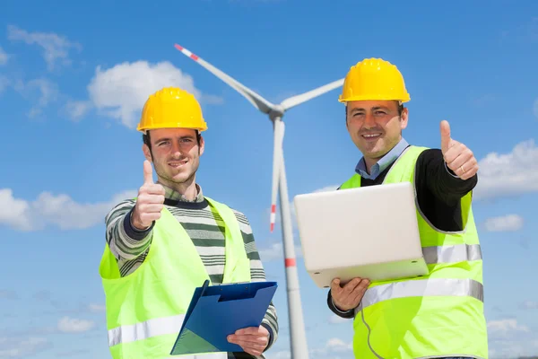技术员工程师竖起大拇指与风力发电机 - 图库照