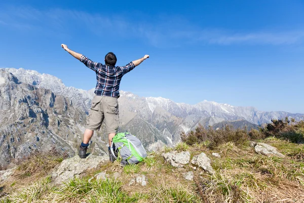 Happy Young Man at Top of the Mountain