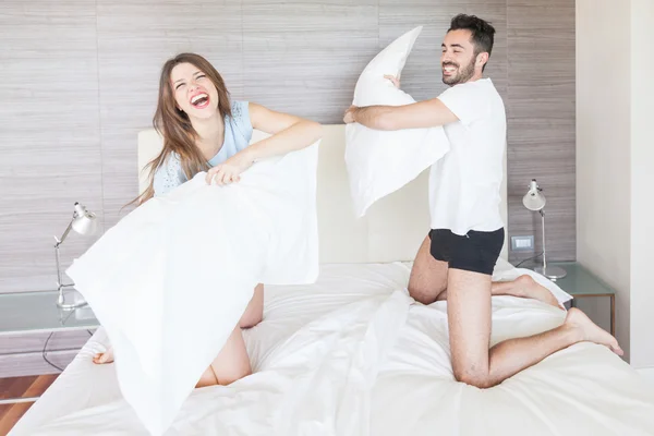 Happy Couple Having Pillow Fight in Hotel Room