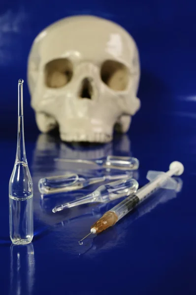 Medical syringe, ampoules and skull