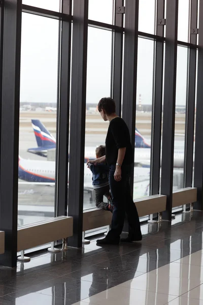 Mother with son looking at airplane