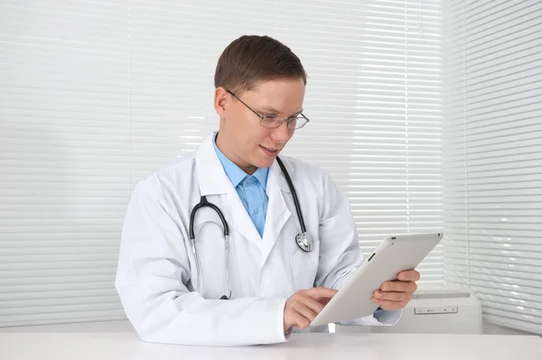 Smiling doctor with tablet computer