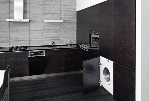 Part of black hardwood kitchen with build-in domestic technique